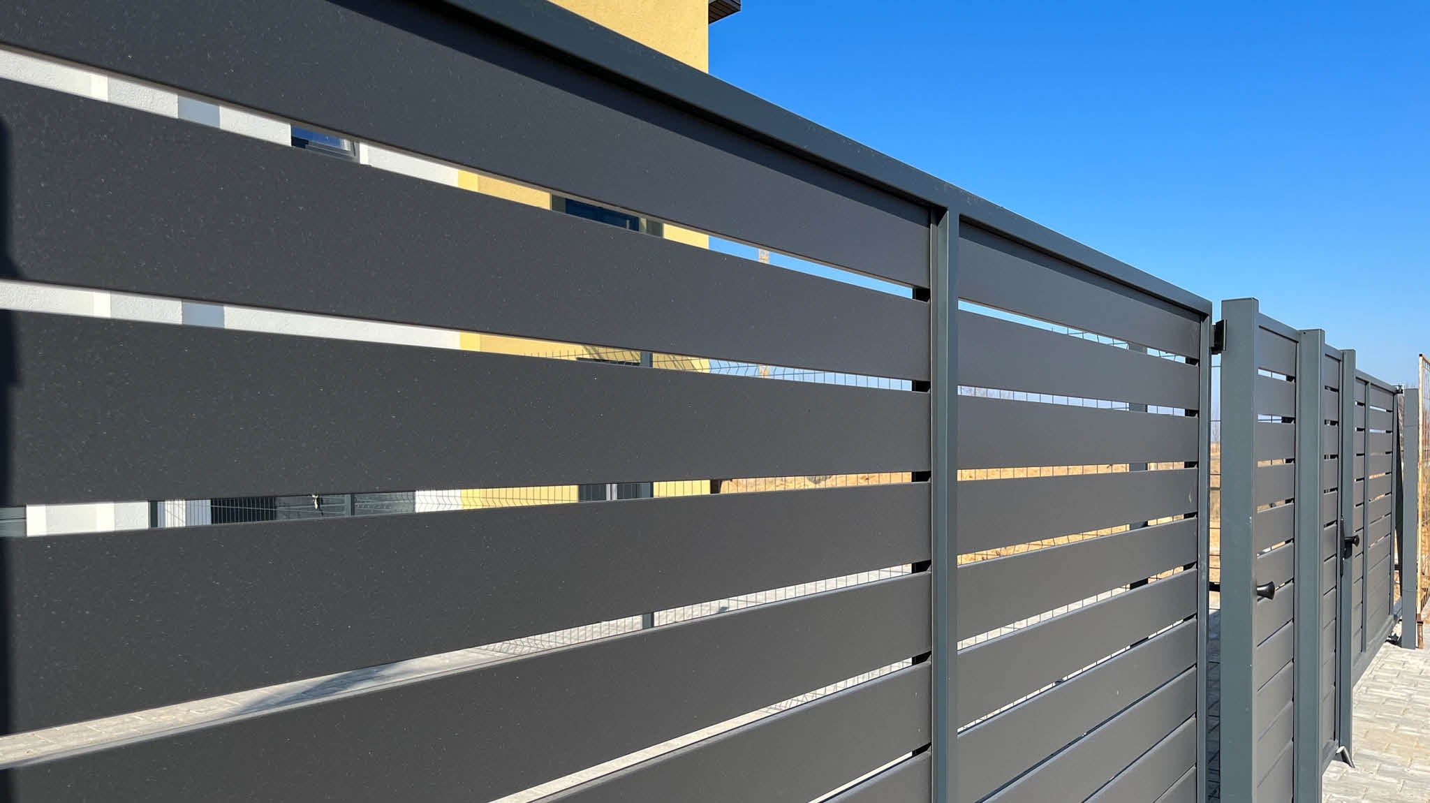 Zaun mit Tor aus schwarzem Metall